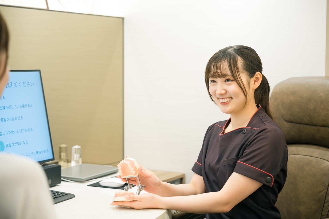歯科助手・受付スタッフが模型を使って説明している様子