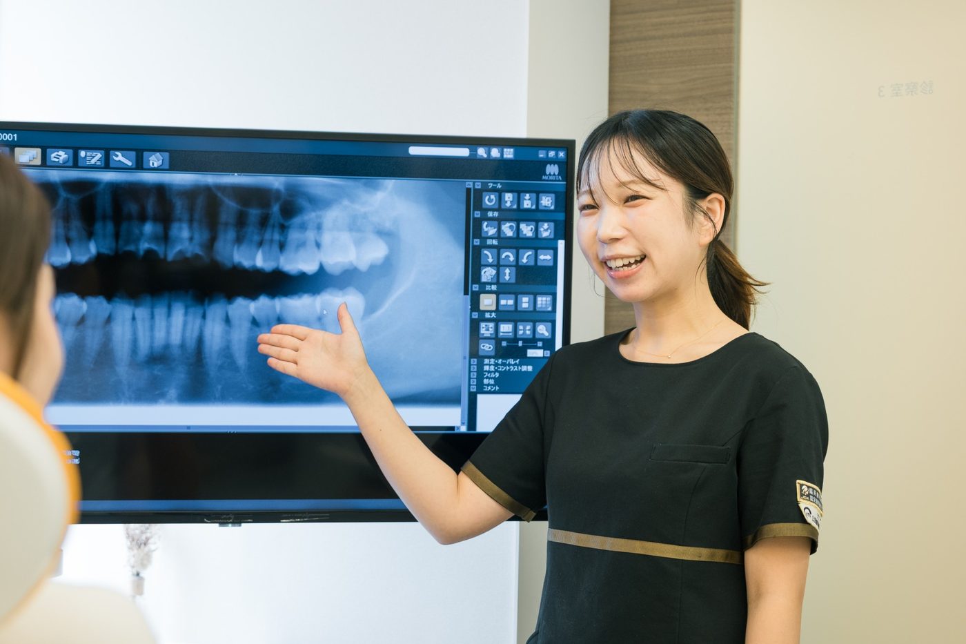 レントゲンを見せながら患者さまに説明する歯科衛生士
