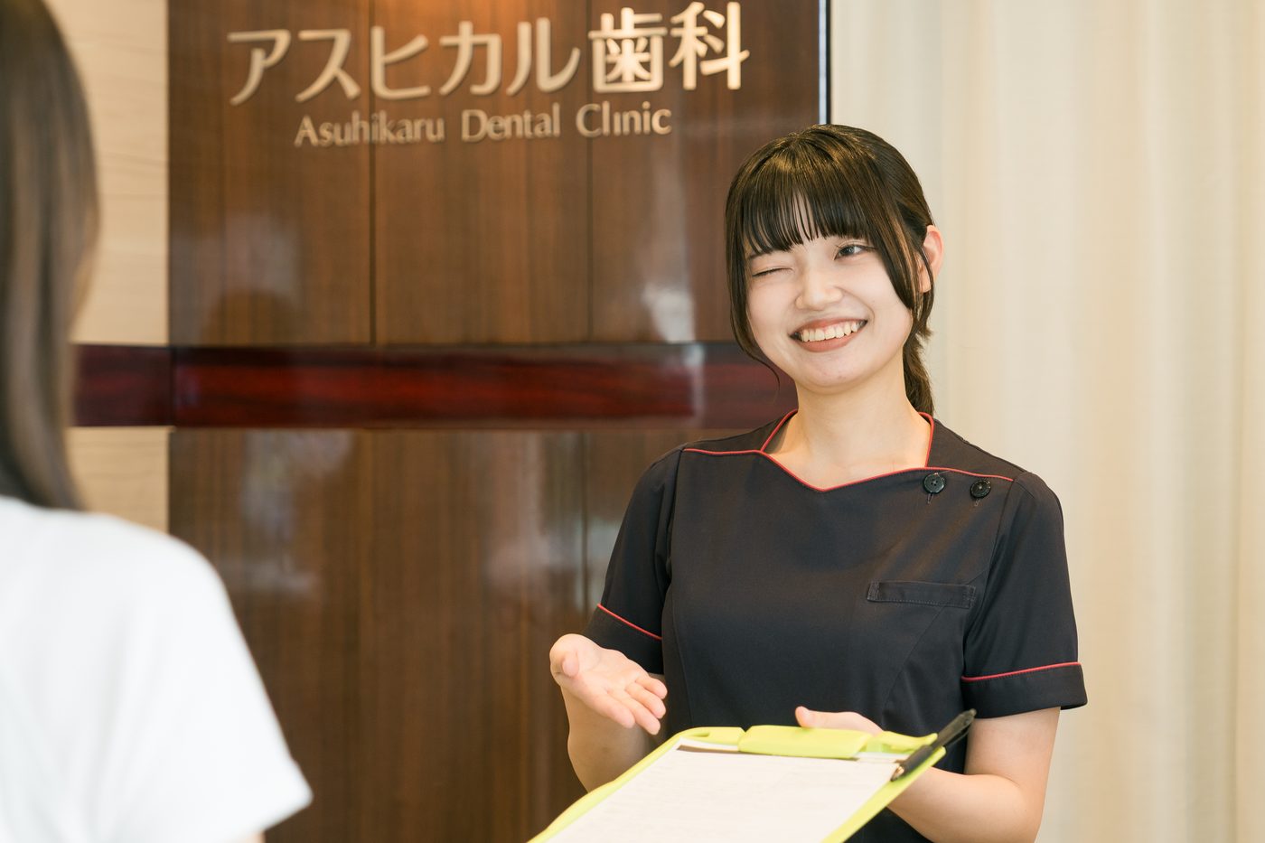 受付で患者さまに説明するスタッフ